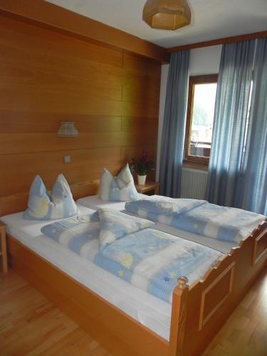 a bedroom with two beds with blue and white pillows at Schwaighof in Oberau
