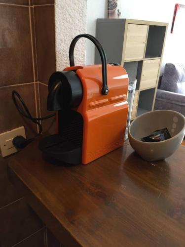 an orange toaster sitting on top of a wooden table at APPARTEMENT REZ DE JARDIN EMPLACEMENT #1 in Empuriabrava