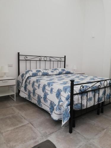 a bedroom with a bed with a blue and white comforter at Casa Vacanze Scicli Centro in Scicli