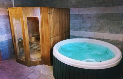 a hot tub in a bathroom with a wooden cabinet at Szalowa Sport Arena in Szalowa