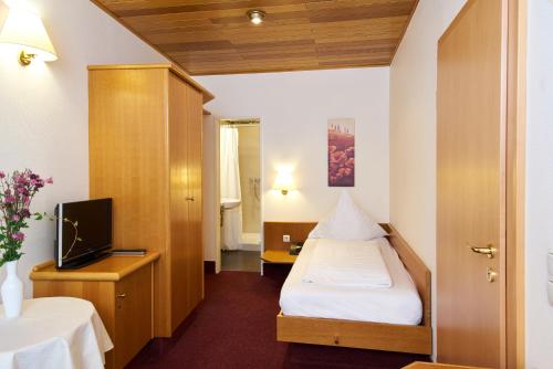 a hotel room with a bed and a tv at Landhotel Krolik in Daun