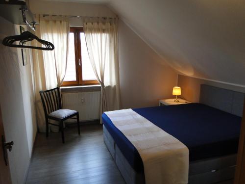 - une chambre avec un lit, une chaise et une fenêtre dans l'établissement Ferienwohnung Am Klosterberg 6, à Bad Brückenau