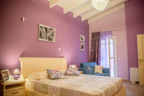a bedroom with purple walls and a bed and a blue chair at Villa Nitsa in Corfu Town