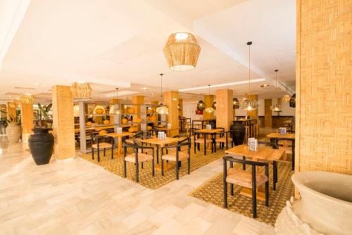 a restaurant with tables and chairs in a room at FERGUS Style Bahamas in Playa d'en Bossa
