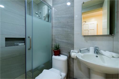 a bathroom with a toilet and a sink and a shower at Bernardo's Lantia Hotel in Basco