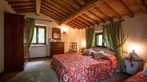 a bedroom with a bed and a dresser and two windows at Poggio Al Palio in San Lorenzo a Merse