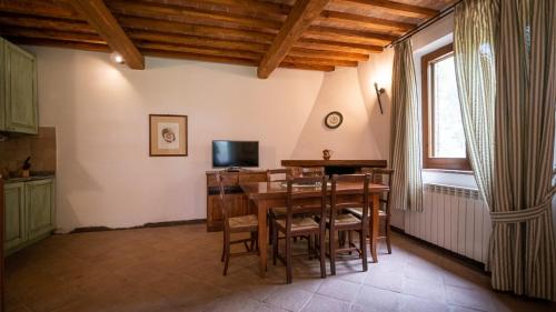a kitchen and dining room with a table and chairs at Poggio Al Palio in San Lorenzo a Merse