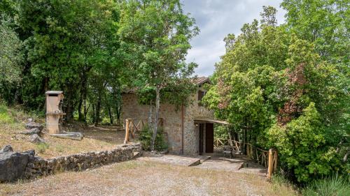 an old stone house in the middle of trees at Poggio Al Palio in San Lorenzo a Merse