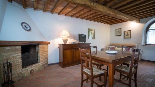 a living room with a wooden table and a fireplace at Poggio Al Palio in San Lorenzo a Merse
