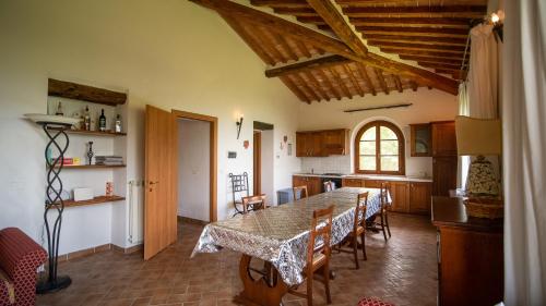 a kitchen with a table and chairs in a room at Poggio Al Palio in San Lorenzo a Merse