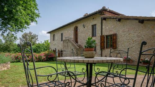 a table and chairs in front of a building at Poggio Al Palio in San Lorenzo a Merse