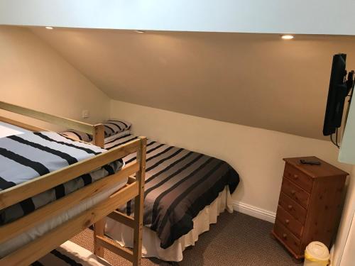 a bedroom with two bunk beds and a tv at Beach View Holiday Flats in Blackpool