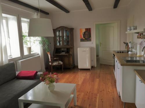 eine Küche und ein Wohnzimmer mit einem Tisch und einem Kühlschrank in der Unterkunft elbe511ferienzuhause in Dömitz