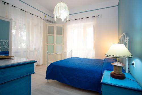 een blauwe slaapkamer met een bed en een lamp bij orizzonti di mare in Marina di Camerota