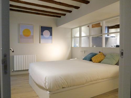 um quarto com uma grande cama branca e janelas em El Oasis de la Estafeta em Pamplona