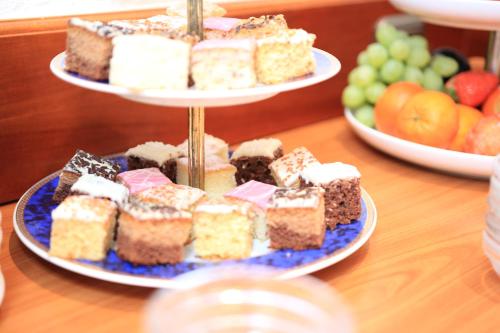 two plates of cakes on a table with fruit at Hotel Erbprinzenpalais in Wernigerode