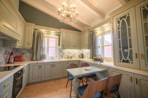 a kitchen with a table and chairs and a chandelier at Villa Nitsa in Corfu Town