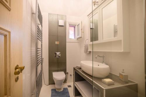 a white bathroom with a sink and a toilet at Villa Nitsa in Corfu Town