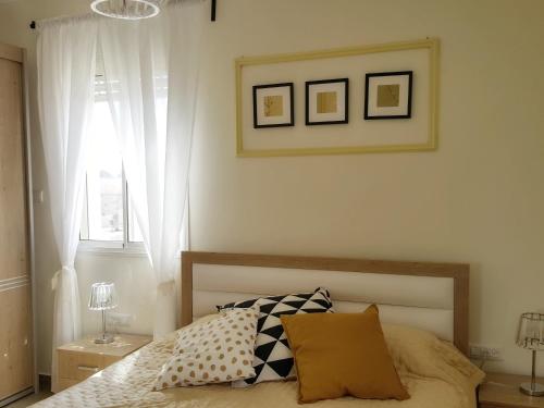 una camera da letto con un letto con due cuscini e una finestra di Our Place At The Desert a Midreshet Ben Gurion