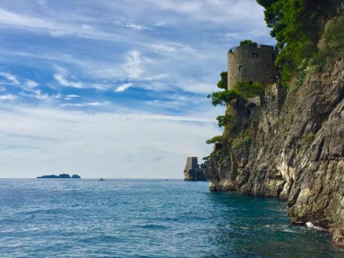 un castillo en un acantilado junto al océano en Torre Silja en Positano