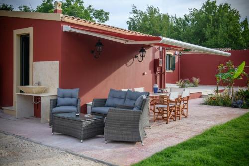 a patio with chairs and a table in front of a house at Villa Nitsa in Corfu Town