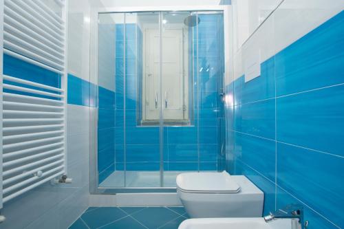 een blauw betegelde badkamer met een toilet en een douche bij orizzonti di mare in Marina di Camerota