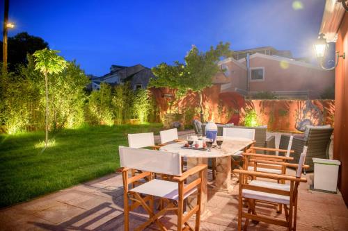 a patio with a table and chairs in a yard at Villa Nitsa in Corfu Town