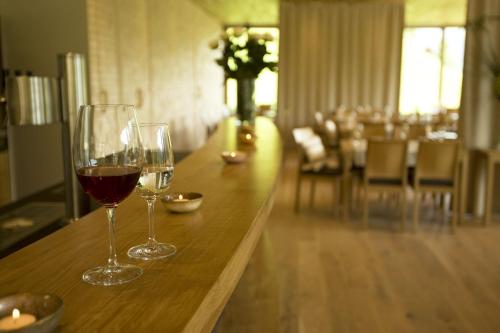 two glasses of wine sitting on a wooden table at Hotel Alpenrose Ebnit in Dornbirn