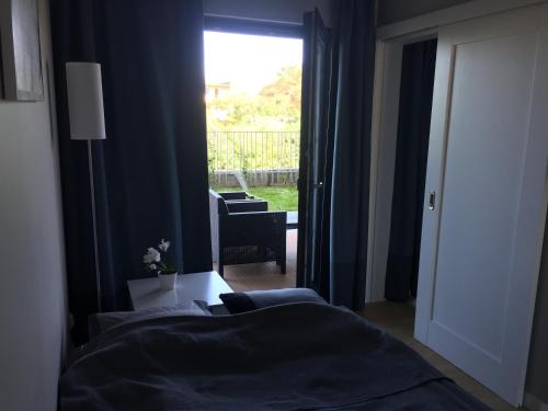 a bedroom with two beds and a window with a chair at Apartament Fala Gardenia Seaside in Dziwnów