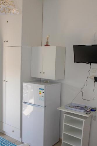 a white kitchen with a refrigerator and white cabinets at The Twins in Glífa