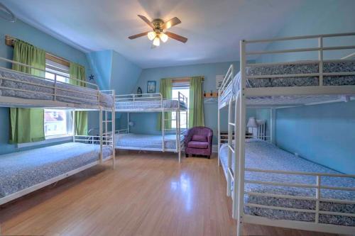 um quarto com 4 beliches e uma ventoinha de tecto em HI Charlottetown Backpacker's Inn em Charlottetown