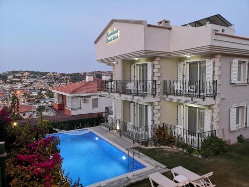 uma casa grande com uma piscina em frente em Kandıra Butik Hotel em Cesme