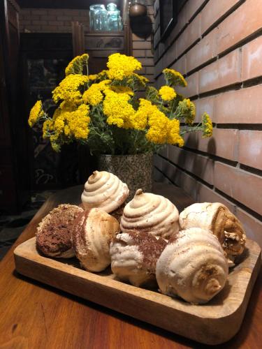 a tray of pastries on a table with a vase of flowers at Bloom Boutique Hotel in Tbilisi City