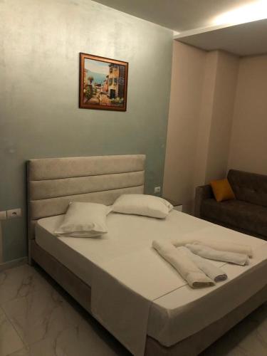 a bed with two pillows and a couch in a room at Summer Gate Hotel in Ksamil