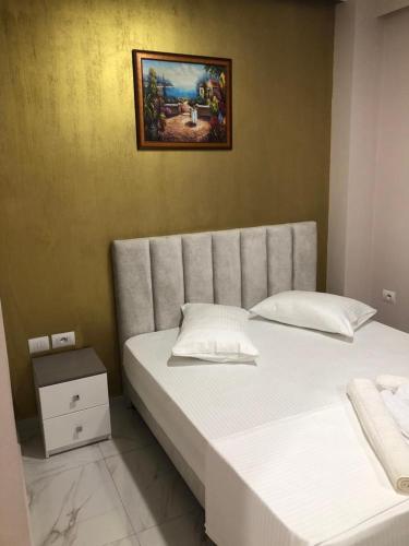 a bedroom with two beds and a picture on the wall at Summer Gate Hotel in Ksamil