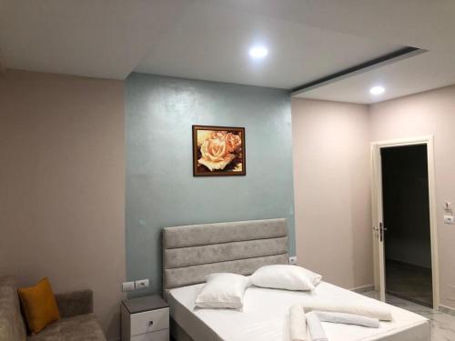 a bedroom with a bed with a picture on the wall at Summer Gate Hotel in Ksamil