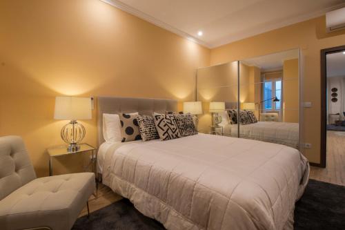 um quarto com uma cama grande e um espelho em Apartamentos Rosa do Bairro Alto em Lisboa