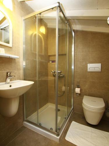 a bathroom with a shower and a toilet and a sink at Kandıra Butik Hotel in Çeşme