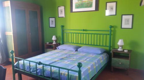 - une chambre verte avec un lit et des murs verts dans l'établissement La Quiete tra le colline, à Dego
