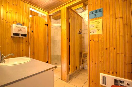 a bathroom with a sink and wooden walls at HI Charlottetown Backpacker's Inn in Charlottetown