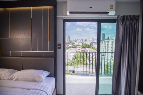 a bedroom with a window with a view of a city at Hallton Hotel Bangkok in Bangkok