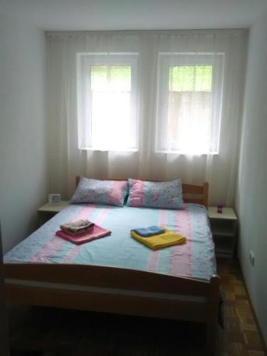 a bedroom with a bed with two towels on it at Apartman Jevtić 1 in Gornja Toplica