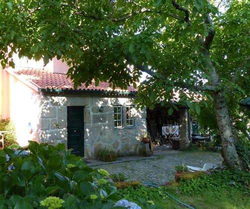 a stone house with a tree in front of it at Casas do Toural in Gouveia