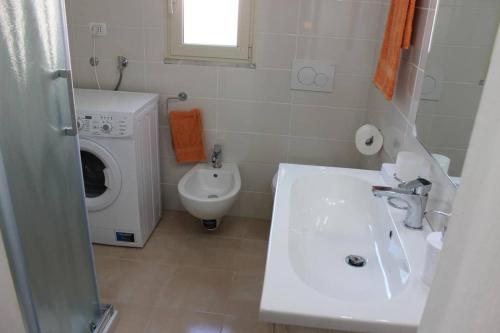a bathroom with a sink and a washing machine at A Casa di Anna in Specchia