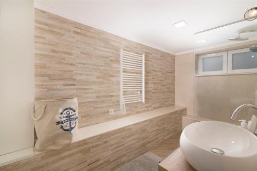 a bathroom with a sink and a toilet and a window at Solymar in Posedarje
