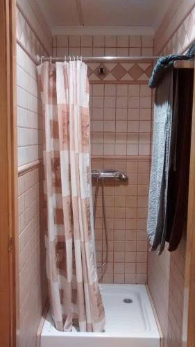a shower with a shower curtain in a bathroom at Hostal Sant Roc in Botarell