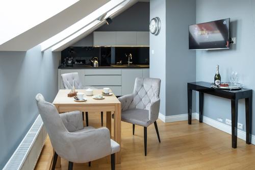 a kitchen and dining room with a table and chairs at Moon River Apartments Gdansk Old Town in Gdańsk