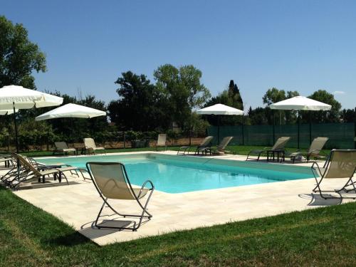 uma piscina com cadeiras e guarda-sóis em Casale San Rufino D'Arce em Assisi