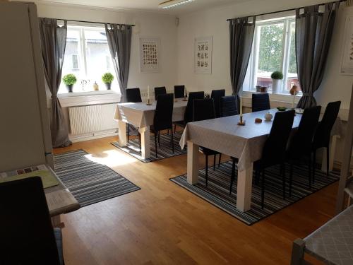 a dining room with tables and chairs and windows at Brukshotellet Skinnsberg in Skinnskatteberg