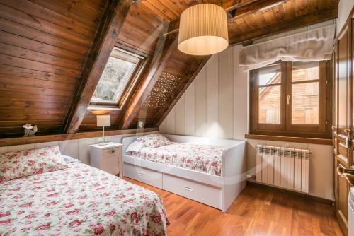 two beds in a bedroom with wooden ceilings at BACIVER in Aubert
